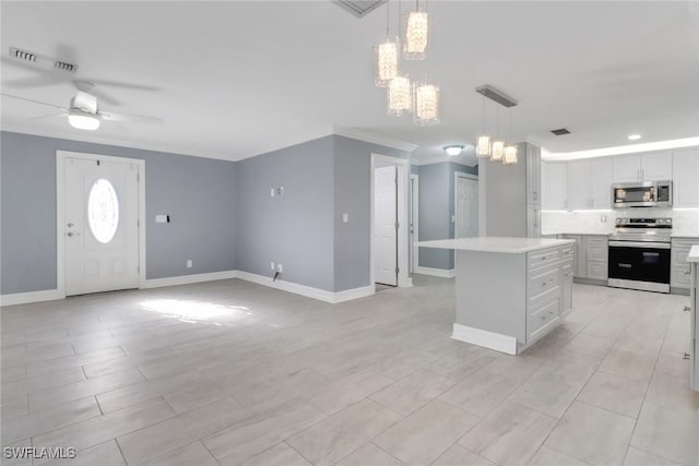 2324 Westwood Rd, North Fort Myers, FL 33917 - kitchen featuring ceiling fan with notable chandelier, visible vents, a kitchen island, light countertops, and stainless steel appliances