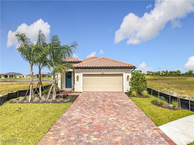 6329 Honor Way, Ave Maria, FL 34142 - view of front facade with a front yard, an attached garage, fence, and decorative driveway