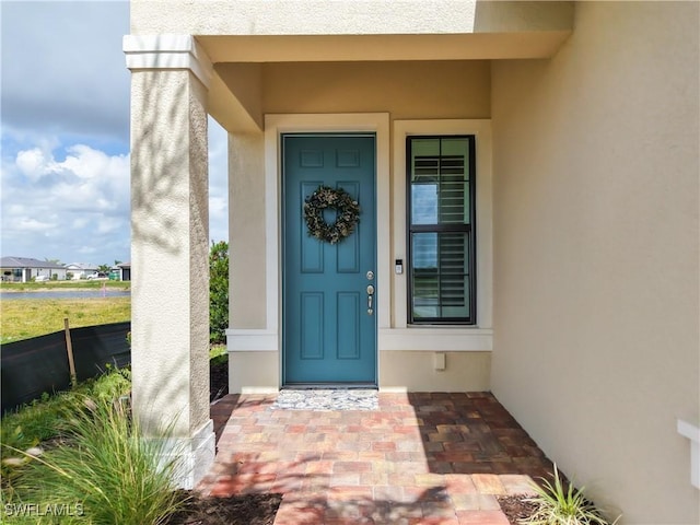 view of exterior entry with stucco siding