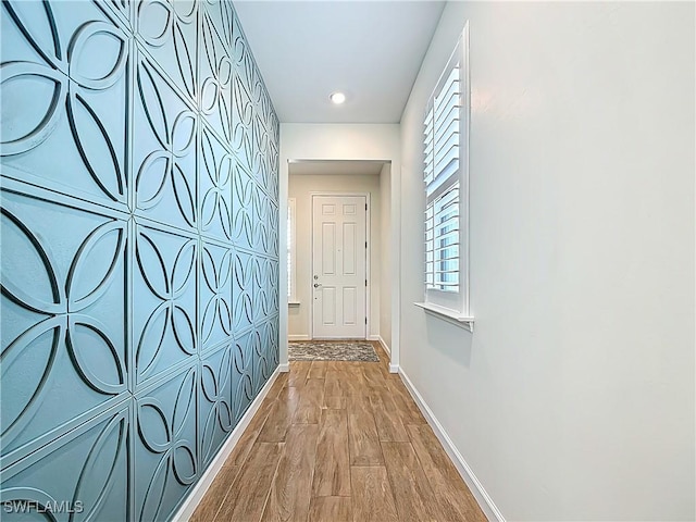 hall with baseboards and wood finished floors