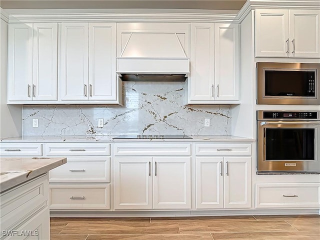 kitchen with stainless steel appliances, white cabinets, wood finish floors, and custom range hood
