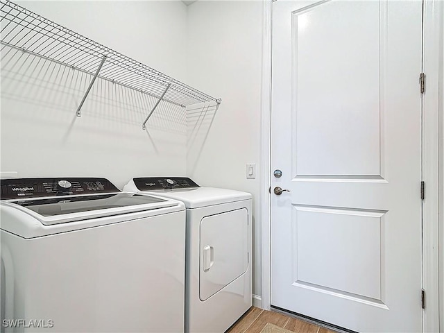 washroom featuring light wood-style flooring, independent washer and dryer, and laundry area