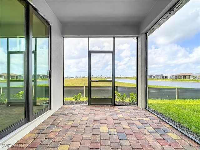 unfurnished sunroom with a water view