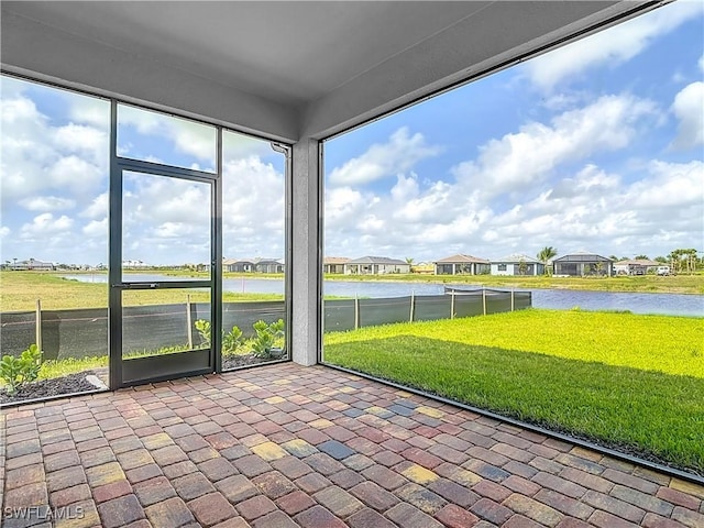 unfurnished sunroom featuring a water view