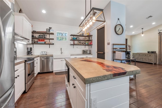 482 10th Ave NW, Naples, FL 34120 - kitchen featuring stainless steel appliances, open shelves, decorative backsplash, white cabinetry, and dark wood finished floors