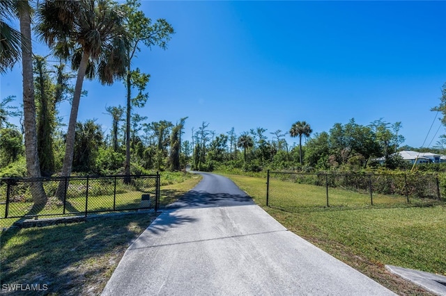 482 10th Ave NW, Naples, FL 34120 - view of concrete driveway with a gated entry and a gate