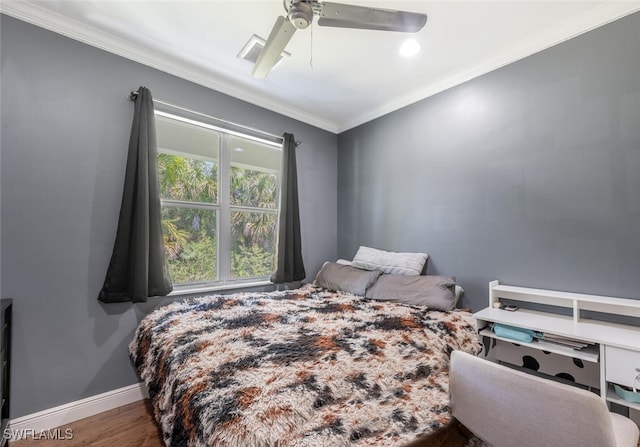 bedroom featuring crown molding, baseboards, ceiling fan, and wood finished floors