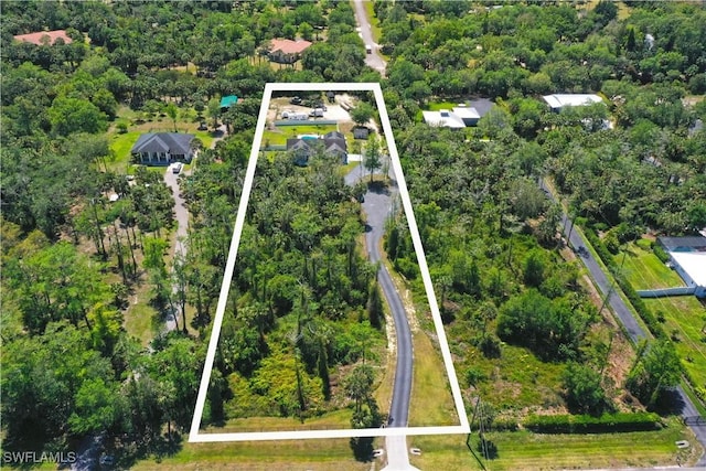 birds eye view of property featuring a forest view