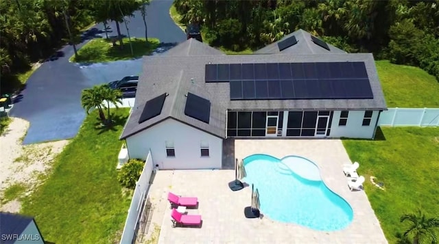 482 10th Ave NW, Naples, FL 34120 - back of house featuring roof mounted solar panels, a patio area, an outdoor pool, and a fenced backyard