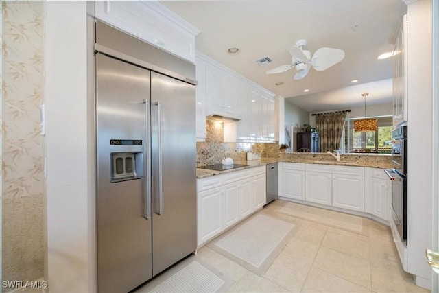 730 Waterford Dr Unit 102, Naples, FL 34113 - kitchen featuring light stone countertops, visible vents, white cabinets, and appliances with stainless steel finishes