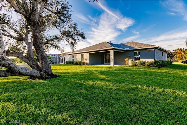 27260 Porto Nacional Dr, Punta Gorda, FL 33983 - back of house with stucco siding, a yard, and roof with shingles