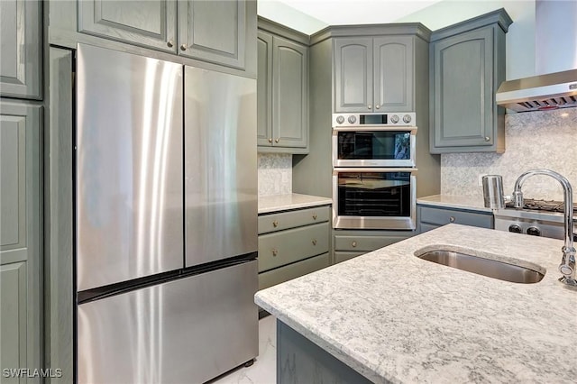 27231 Lakeway Ct, Bonita Springs, FL 34134 - kitchen featuring gray cabinets, backsplash, a sink, wall chimney exhaust hood, and stainless steel appliances