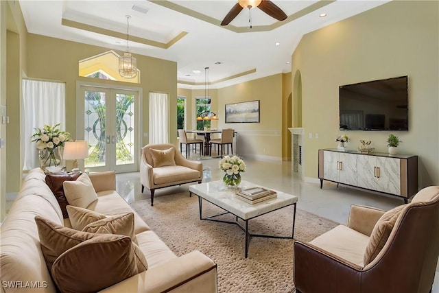 27231 Lakeway Ct, Bonita Springs, FL 34134 - living room featuring a tray ceiling, french doors, visible vents, arched walkways, and ceiling fan