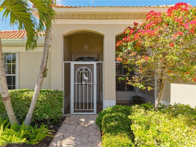 20716 Tisbury Ln, North Fort Myers, FL 33917 - property entrance with a tiled roof and stucco siding