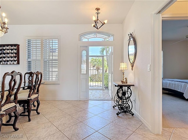 20716 Tisbury Ln, North Fort Myers, FL 33917 - foyer featuring light tile patterned floors, a notable chandelier, and baseboards