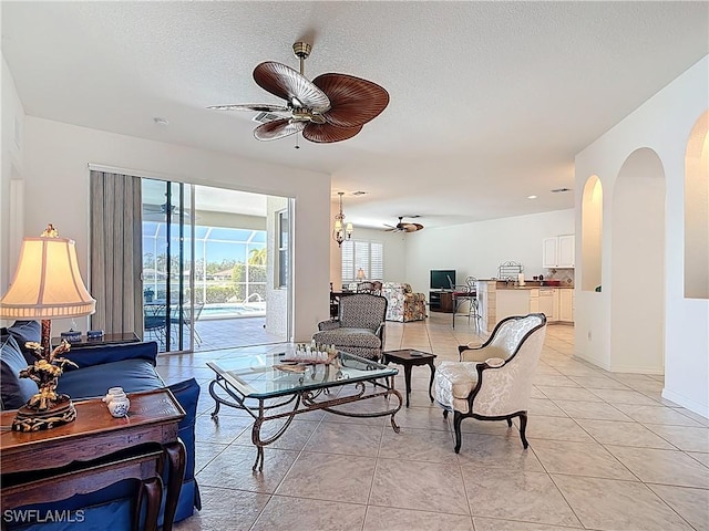 20716 Tisbury Ln, North Fort Myers, FL 33917 - living room featuring baseboards, a textured ceiling, light tile patterned flooring, ceiling fan, and arched walkways