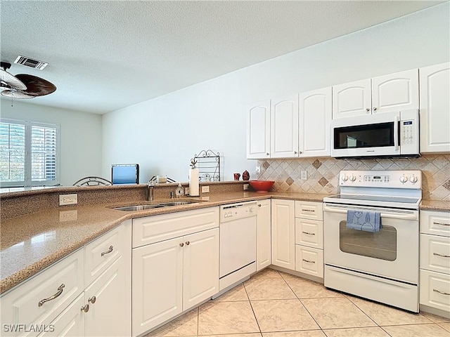 20716 Tisbury Ln, North Fort Myers, FL 33917 - kitchen with tasteful backsplash, light tile patterned floors, white cabinets, a sink, and white appliances