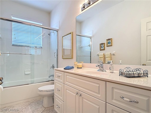 20716 Tisbury Ln, North Fort Myers, FL 33917 - full bath with tile patterned floors, vanity, toilet, and bath / shower combo with glass door