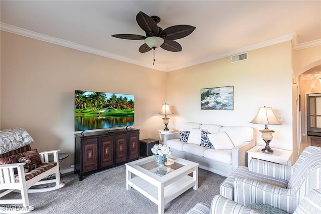 carpeted living room featuring crown molding, arched walkways, a ceiling fan, and visible vents