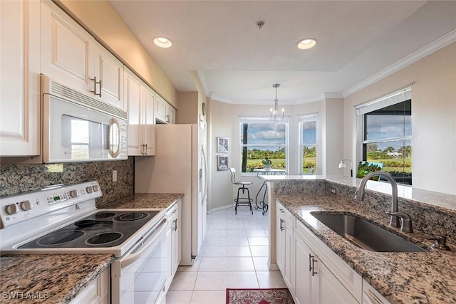 kitchen with a sink, plenty of natural light, white appliances, and a chandelier