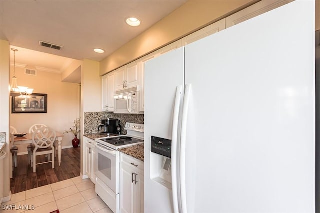 kitchen featuring backsplash, visible vents, light tile patterned floors, white appliances, and white cabinetry