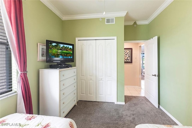 carpeted bedroom with baseboards, visible vents, ornamental molding, and a closet