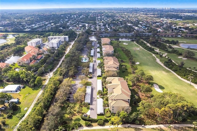 drone / aerial view with a water view, view of golf course, and a residential view