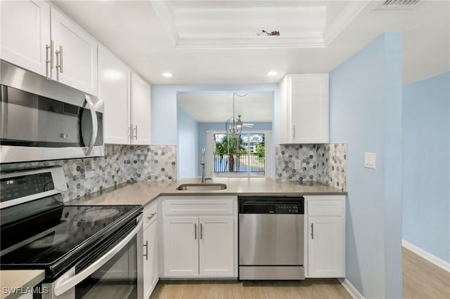 1004 Manatee Rd Unit H201, Naples, FL 34114 - kitchen featuring stainless steel appliances, light wood-style flooring, white cabinetry, a raised ceiling, and recessed lighting