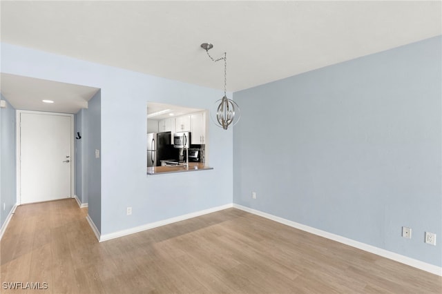 1004 Manatee Rd Unit H201, Naples, FL 34114 - unfurnished dining area featuring wood finished floors and a chandelier