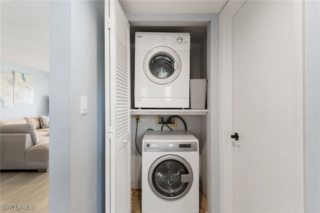 1004 Manatee Rd Unit H201, Naples, FL 34114 - laundry room featuring stacked washing machine and dryer and wood finished floors