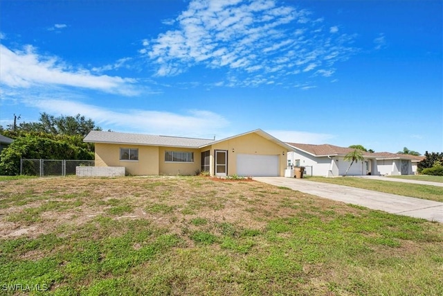 single story home featuring a front lawn, an attached garage, driveway, stucco siding, and fence