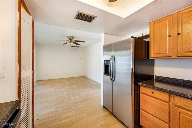 kitchen featuring visible vents, light wood finished floors, stainless steel refrigerator with ice dispenser, a ceiling fan, and brown cabinetry