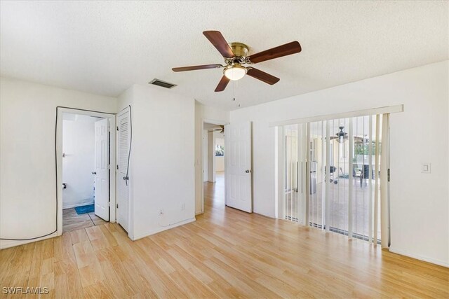 unfurnished bedroom featuring visible vents, light wood-type flooring, access to outside, and baseboards
