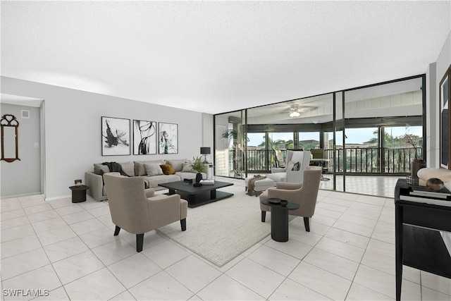 845 Collier Ct Unit 503, Marco Island, FL 34145 - living area with light tile patterned floors, ceiling fan, expansive windows, baseboards, and a textured ceiling