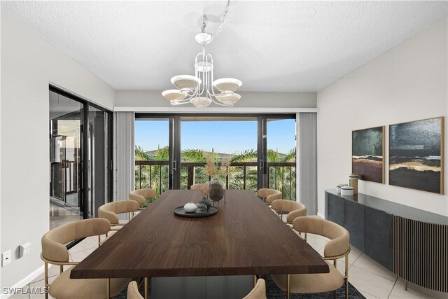 845 Collier Ct Unit 503, Marco Island, FL 34145 - dining space with a chandelier, healthy amount of natural light, light tile patterned floors, a textured ceiling, and baseboards