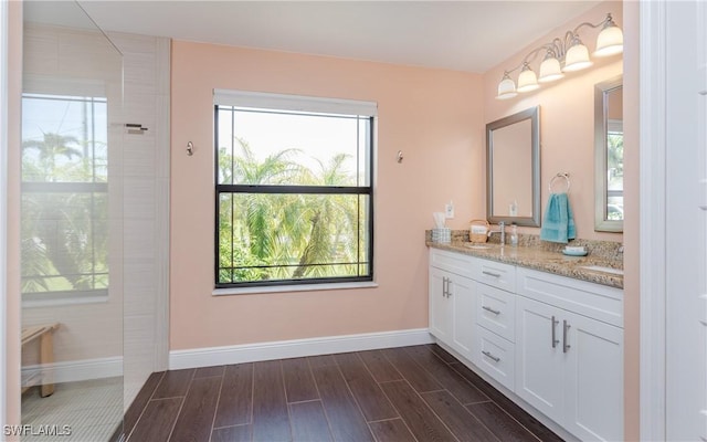 2714 SW 28th Ave, Cape Coral, FL 33914 - bathroom featuring a sink, baseboards, wood tiled floor, and double vanity