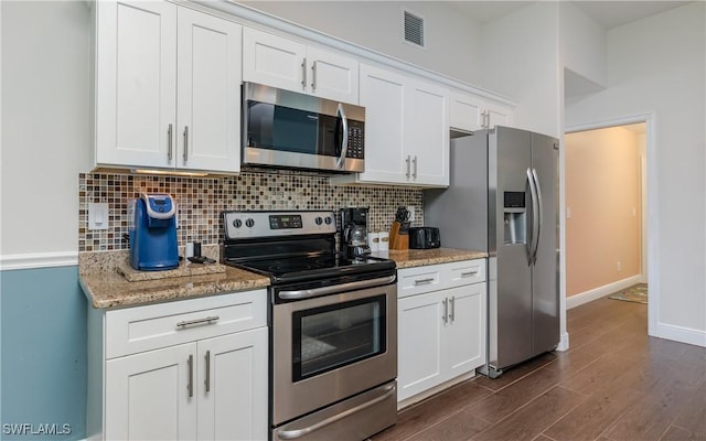 2714 SW 28th Ave, Cape Coral, FL 33914 - kitchen featuring white cabinets, visible vents, stainless steel appliances, dark wood-type flooring, and backsplash