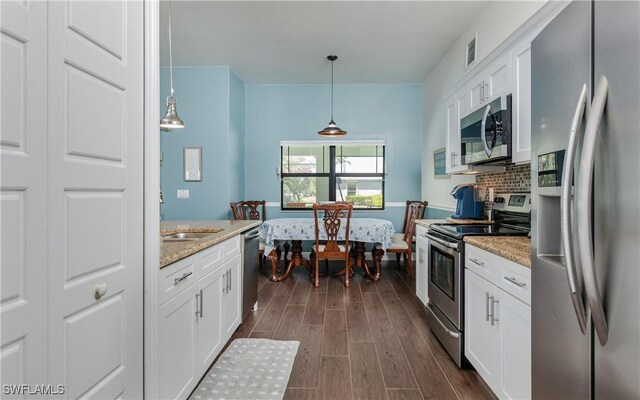 2714 SW 28th Ave, Cape Coral, FL 33914 - kitchen with white cabinets, a sink, stainless steel appliances, and dark wood finished floors