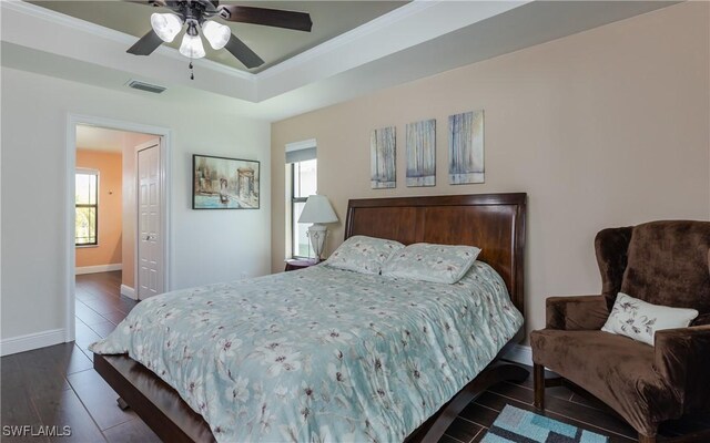 2714 SW 28th Ave, Cape Coral, FL 33914 - bedroom featuring a tray ceiling, wood finished floors, baseboards, visible vents, and ornamental molding
