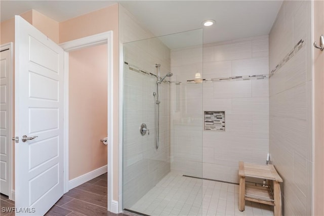 2714 SW 28th Ave, Cape Coral, FL 33914 - bathroom featuring baseboards, a tile shower, and wood finish floors