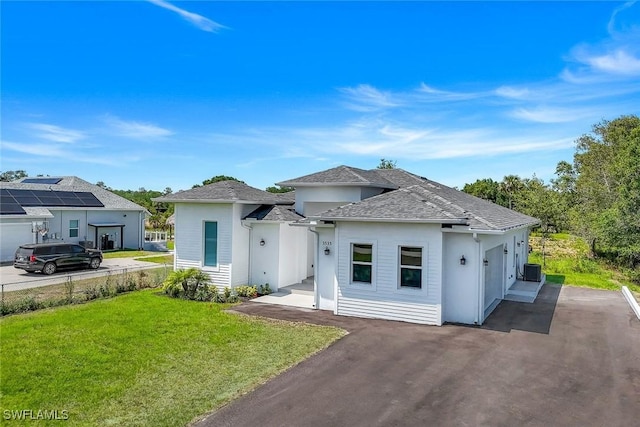 3533 22nd Ave SE, Naples, FL 34117 - view of front facade with stucco siding, driveway, a front lawn, central AC unit, and a garage