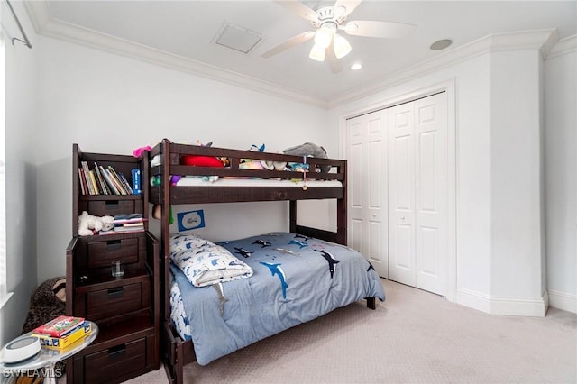 carpeted bedroom featuring a closet, ornamental molding, baseboards, and a ceiling fan