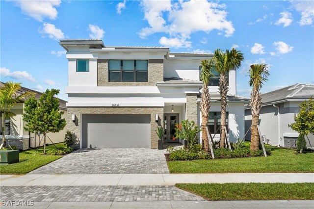 20333 Fair Oak Ln, Estero, FL 33928 - prairie-style house featuring a front lawn, decorative driveway, an attached garage, and stucco siding