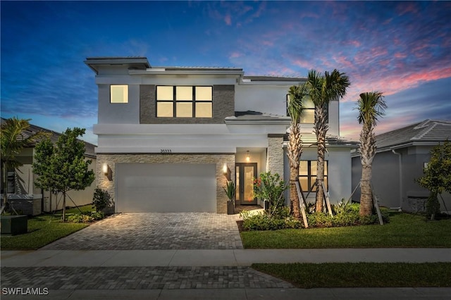 20333 Fair Oak Ln, Estero, FL 33928 - view of front of house featuring stone siding, decorative driveway, a garage, and stucco siding