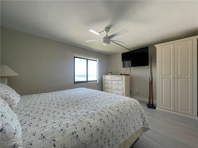 6672 Estero Blvd Unit A606, Fort Myers Beach, FL 33931 - bedroom with light wood-type flooring, a ceiling fan, and baseboards