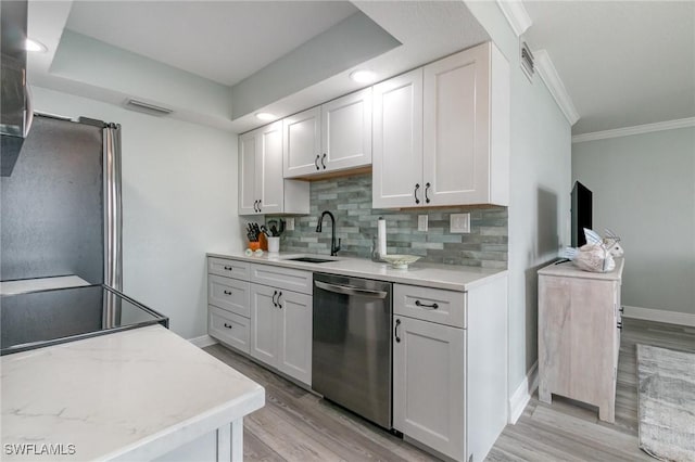 kitchen featuring crown molding, light wood-type flooring, appliances with stainless steel finishes, a sink, and decorative backsplash