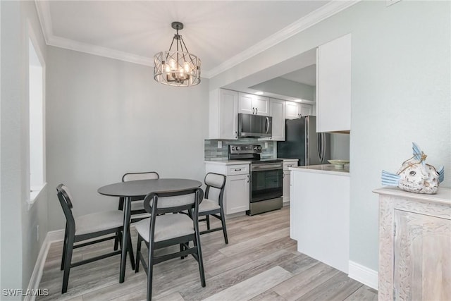 dining space featuring baseboards, light wood-type flooring, an inviting chandelier, and ornamental molding
