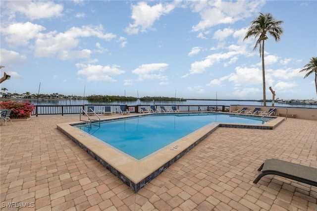 pool featuring a water view and a patio area