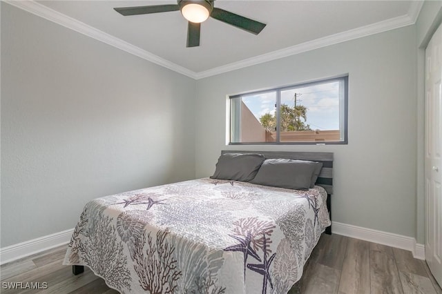 bedroom with ceiling fan, baseboards, crown molding, and wood finished floors