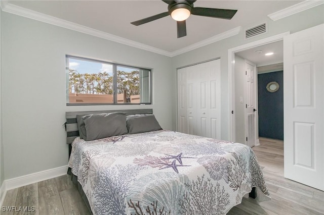 bedroom featuring visible vents, a closet, crown molding, and wood finished floors